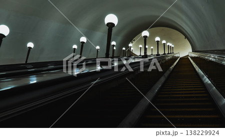 Moscow Metro escalator tunnel with glowing lamps and elegant architecture Moscow Metro escalator tunnel with glowing lamps and elegant architecture 138229924