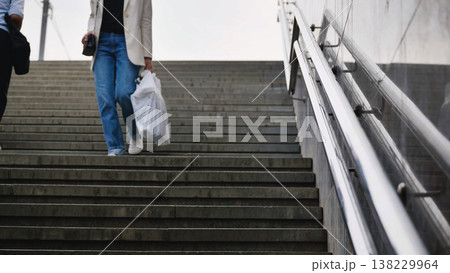 People walking down concrete stairs with groceries, urban commuting and daily life People walking down concrete stairs with groceries, urban commuting and daily life 138229964