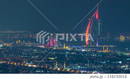 Aerial view of Dubai city skyline at night with illuminated burj al arab hotel timelapse. Aerial view of Dubai city skyline at night with illuminated burj al arab hotel timelapse. 138230018