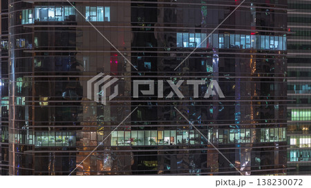 Office skyscraper exterior during late evening with interior lights on and people working inside night timelapse Office skyscraper exterior during late evening with interior lights on and people working inside night timelapse 138230072