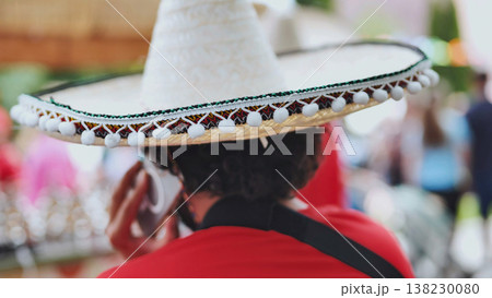 Man in sombrero talking on cell phone at a vibrant outdoor festival Man in sombrero talking on cell phone at a vibrant outdoor festival 138230080