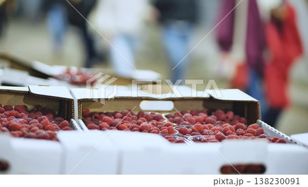 Fresh raspberries in cardboard boxes and plastic containers at a fruit market stall 138230091