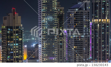 View of various skyscrapers and towers in Dubai Marina from above aerial night timelapse 138230143