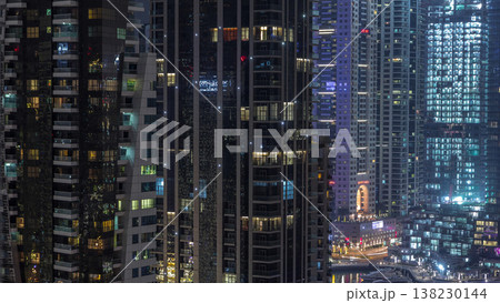 Aerial view of Dubai Marina residential and office skyscrapers with waterfront night timelapse Aerial view of Dubai Marina residential and office skyscrapers with waterfront night timelapse 138230144