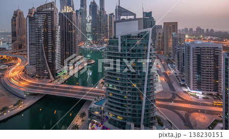 Aerial view of Dubai Marina residential and office skyscrapers with waterfront night to day timelapse Aerial view of Dubai Marina residential and office skyscrapers with waterfront night to day timelapse 138230151