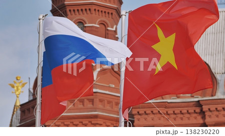 Russian and Vietnamese flags waving together in front of a historic building Russian and Vietnamese flags waving together in front of a historic building 138230220