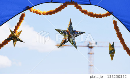 India Day street festival decorations with marigold garlands and star lanterns against clear sky India Day street festival decorations with marigold garlands and star lanterns against clear sky 138230352