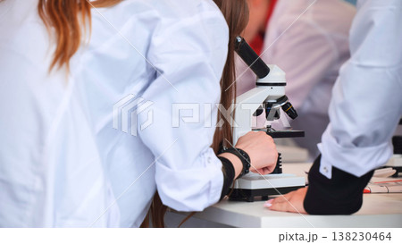 Student working with microscope in science laboratory 138230464