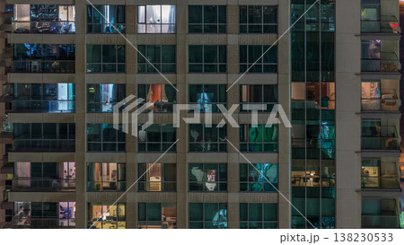 Windows of the multi-storey building with lighting inside and moving people in apartments timelapse. Windows of the multi-storey building with lighting inside and moving people in apartments timelapse. 138230533