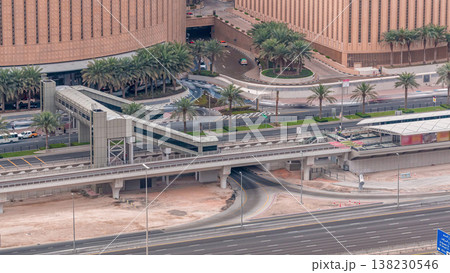 Aerial top view of traffic near mall with footbridge from tram stop timelapse in Dubai Marina in Dubai, UAE. 138230546