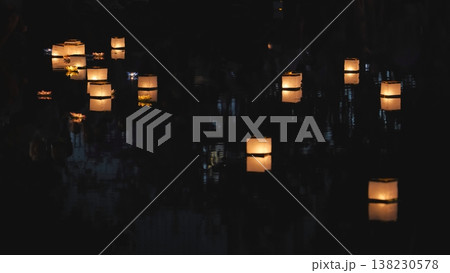 Floating paper lanterns illuminating dark river at night Floating paper lanterns illuminating dark river at night 138230578