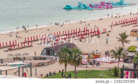 Aerial view of beach and tourists walking and sunbathing on holiday in JBR timelapse in Dubai, UAE Aerial view of beach and tourists walking and sunbathing on holiday in JBR timelapse in Dubai, UAE 138230589