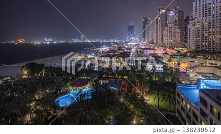 Aerial view of beach and tourists walking in JBR with skyscrapers night timelapse in Dubai, UAE 138230612