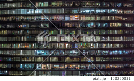 Working evening in glass office building with numerous offices with glass walls and windows timelapse 138230831