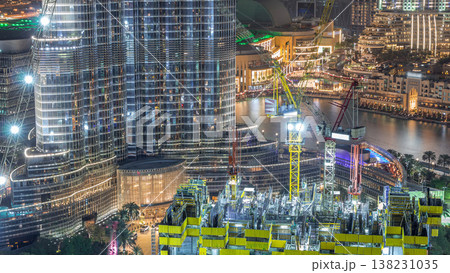 Aerial view of a skyscraper under construction with huge cranes night timelapse in Dubai. 138231035
