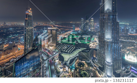 Panoramic skyline view of Dubai downtown with mall, fountains and Burj Khalifa aerial night timelapse 138231117