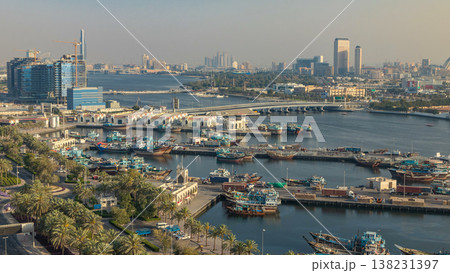 Dubai creek landscape timelapse with boats and ship in port and modern buildings in the background during sunset Dubai creek landscape timelapse with boats and ship in port and modern buildings in the background during sunset 138231397