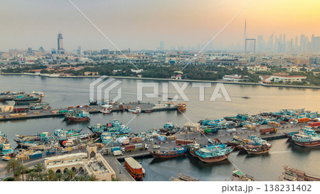 Dubai creek landscape timelapse with boats and ship in port and modern buildings in the background during sunset Dubai creek landscape timelapse with boats and ship in port and modern buildings in the background during sunset 138231402