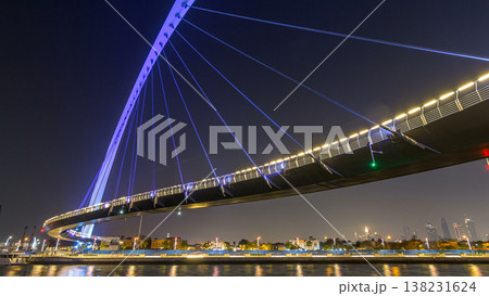 Futuristic Pedestrian Bridge over the Dubai Water Canal Illuminated at Night timelapse hyperlapse, UAE. 138231624
