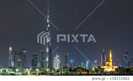 Modern Dubai city skyline timelapse at night with illuminated skyscrapers over water surface 138231662