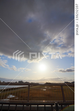 眩しい太陽と広がる雲と川の風景 眩しい太陽と広がる雲と川の風景 138232107