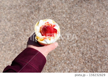いちごクレープを手に持った食べ歩きスイーツ いちごクレープを手に持った食べ歩きスイーツ 138232829