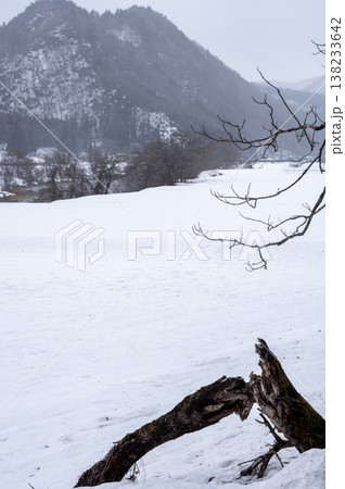 雪降る南会津の冬景色、一面の雪原と雪化粧した山並みが広がる里山の風景 雪降る南会津の冬景色、一面の雪原と雪化粧した山並みが広がる里山の風景 138233642