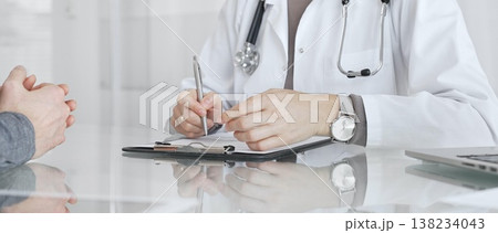 Doctor discussing health status with patient during medical consultation, offering advice in clinic. Medicine and health care Doctor discussing health status with patient during medical consultation, offering advice in clinic. Medicine and health care 138234043