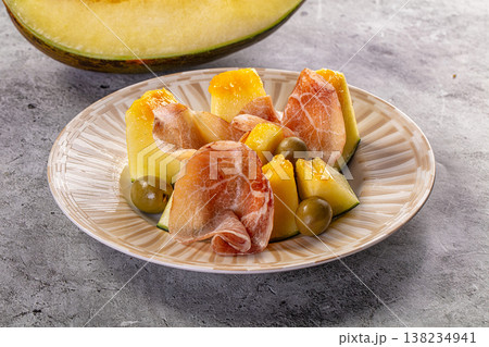 Classic Italian appetizer of melon with prosciutto and green olives on a plate Classic Italian appetizer of melon with prosciutto and green olives on a plate 138234941