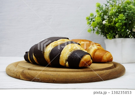 Fresh and tasty croissants on wooden plate 138235853