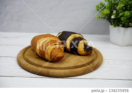Fresh and tasty croissants on wooden plate Fresh and tasty croissants on wooden plate 138235856