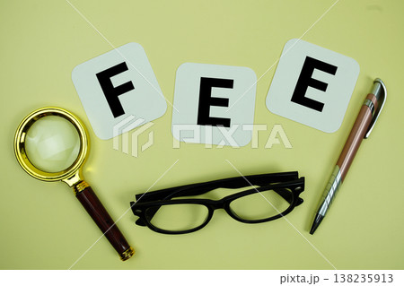 FEE alphabet letters with magnifying glass, eye glasses and pen on yellow background FEE alphabet letters with magnifying glass, eye glasses and pen on yellow background 138235913