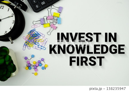 Invest In Knowledge First message with calculator, alarm clock and Stationery on white background 138235947