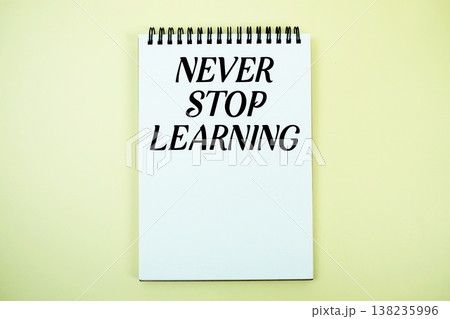 Notepad with message "Never Stop Learning" top view on yellow background 138235996