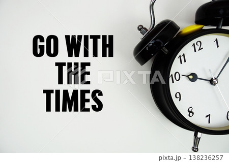Go With The Times text with alarm clock flat lay on white background 138236257