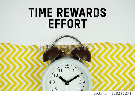Time Rewards Effort text written on paper with alarm clock on yellow chevron background Time Rewards Effort text written on paper with alarm clock on yellow chevron background 138236271
