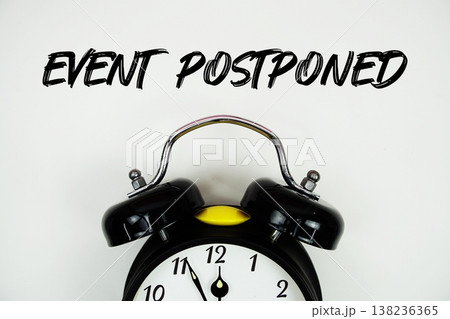 Event Postponed text with alarm clock flat lay on white background Event Postponed text with alarm clock flat lay on white background 138236365