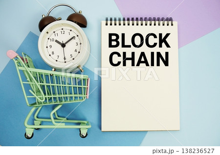 Block Chain text written on notepad with alarm clock and trolley shopping cart 138236527