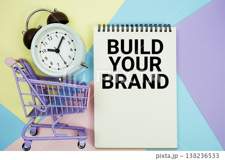Build Your Brand text written on notepad with alarm clock and trolley shopping cart Build Your Brand text written on notepad with alarm clock and trolley shopping cart 138236533