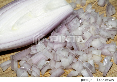 Close up of a chopped shallot onion on a wooden chopping board 138236589