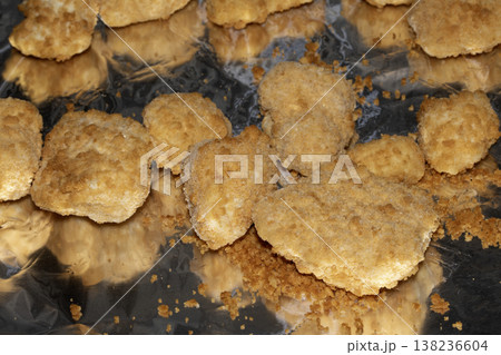 Close up of breaded fish scampi pieces on a tin foil base ready for cooking Close up of breaded fish scampi pieces on a tin foil base ready for cooking 138236604