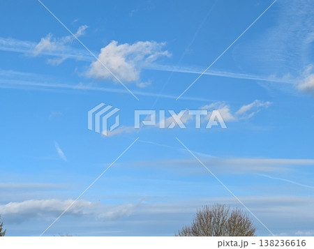 Beautiful blue summer air with fluffy white clouds and chem trail lines across the sky 138236616