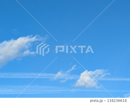 Beautiful blue summer air with fluffy white clouds and chem trail lines across the sky 138236618