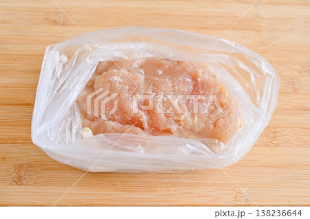 ポリ袋に入れた鶏胸肉に塩をふる ポリ袋に入れた鶏胸肉に塩をふる 138236644