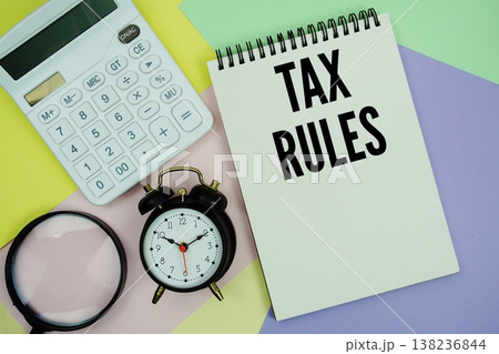 Tax Rules text with calculator, alarm clock and magnifying glass Tax Rules text with calculator, alarm clock and magnifying glass 138236844