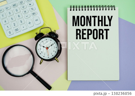 Monthly Report text with calculator, alarm clock and magnifying glass 138236856