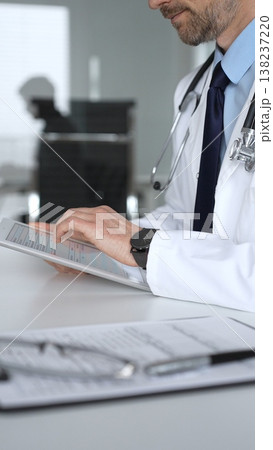 Doctor man interacting with patient during consultation, using digital tablet for modern medical healthcare technology. Medicine, healthcare and science concept Doctor man interacting with patient during consultation, using digital tablet for modern medical healthcare technology. Medicine, healthcare and science concept 138237220