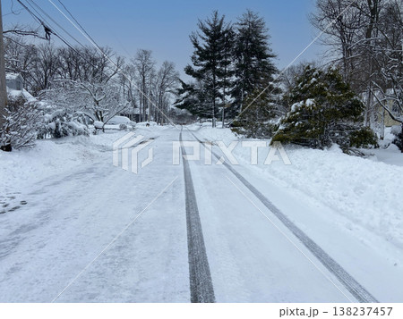 雪に覆われた住宅街の道路とタイヤ跡が残る冬の風景 雪に覆われた住宅街の道路とタイヤ跡が残る冬の風景 138237457