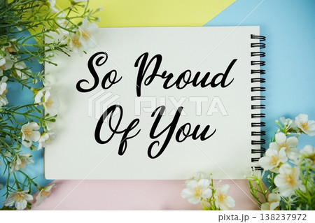 So Proud Of You text written on notepad with flowers decorations flat lay on multicolor pastel background So Proud Of You text written on notepad with flowers decorations flat lay on multicolor pastel background 138237972