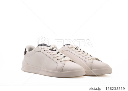 Minimalist white low-top sneakers on plain white background Minimalist white low-top sneakers on plain white background 138238239